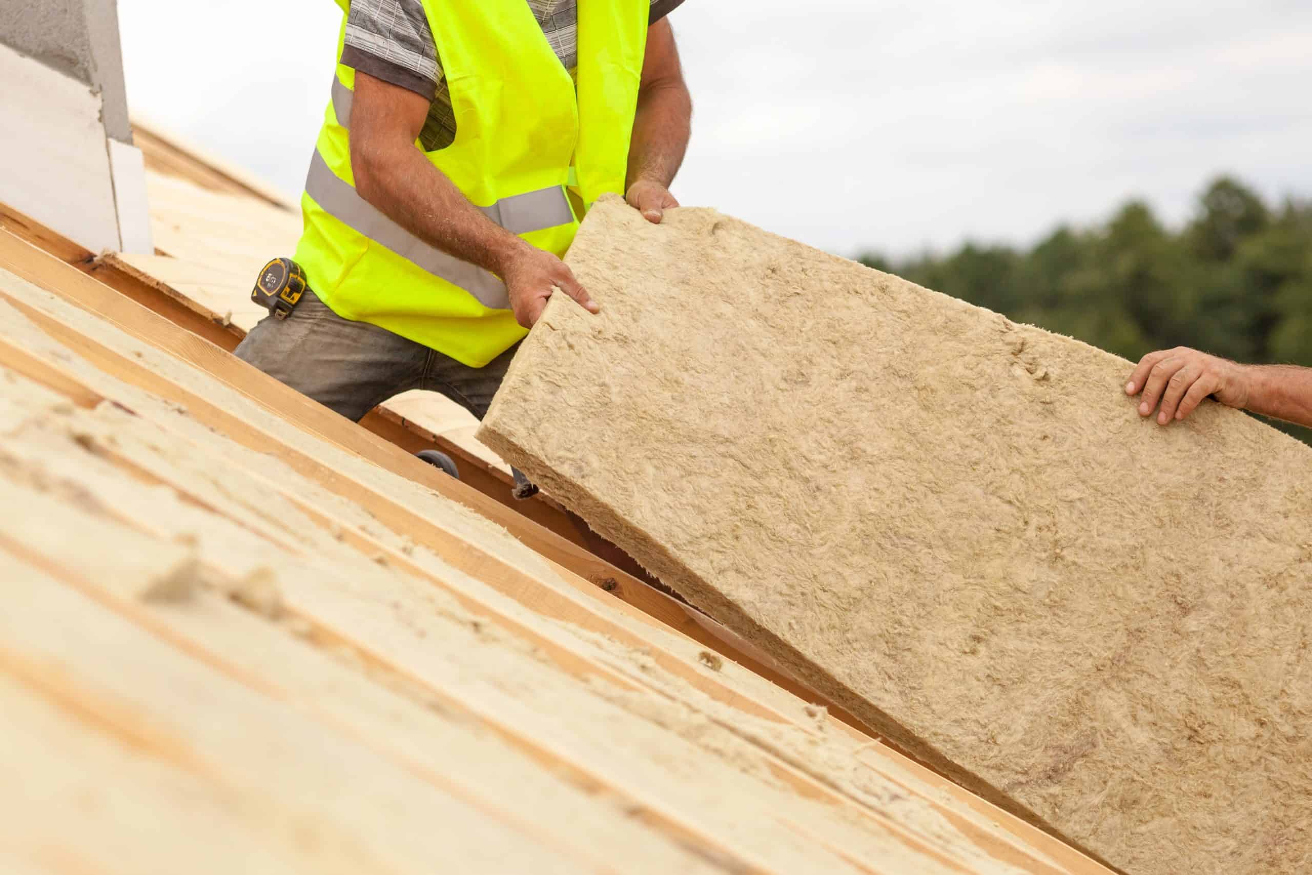A builder on a roof of a building installing roof installation