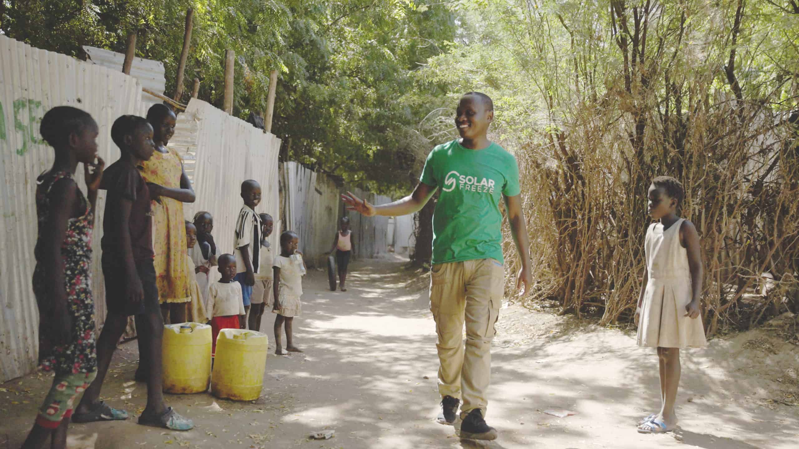 A man in a green shirt walking through the street