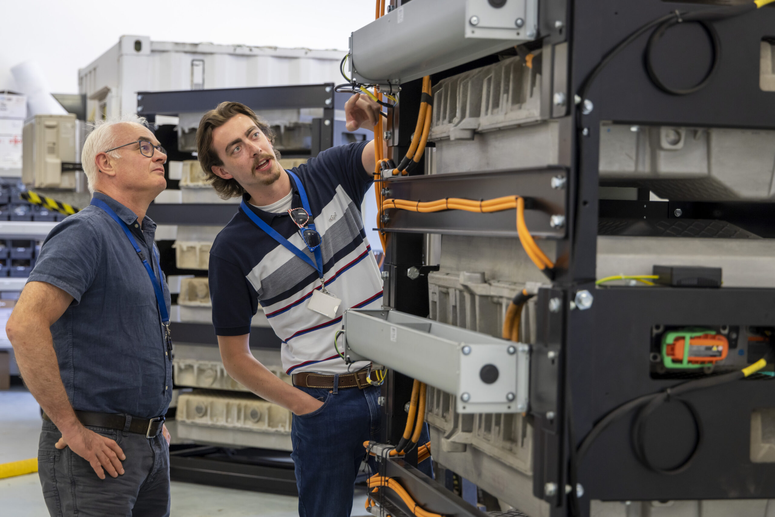 Two males examining one of the battery units at Connected Energy technical facility