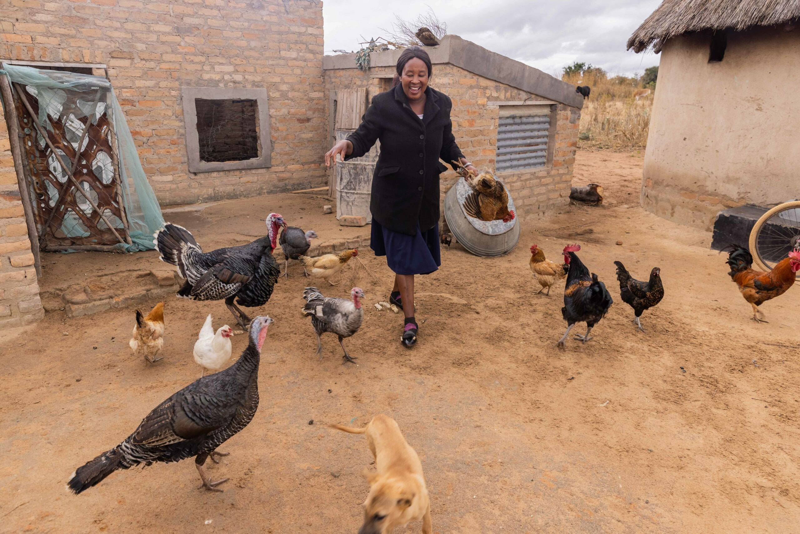 A woman holding a chicken.