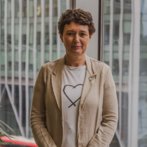 Woman with short brown hair wearing a beige jacket