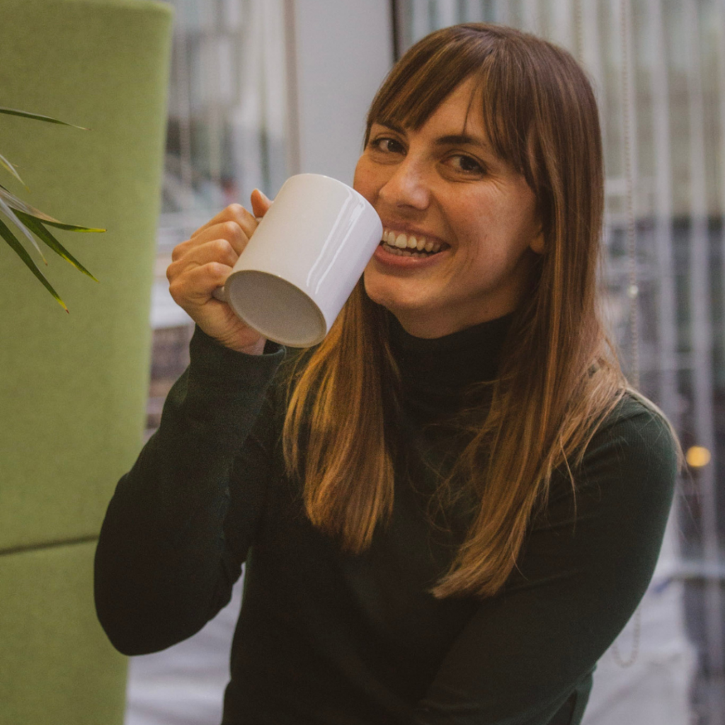 Woman smiling and holding a white mug