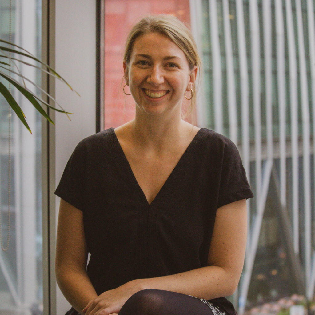 Woman in blue shirt sitting and smiling