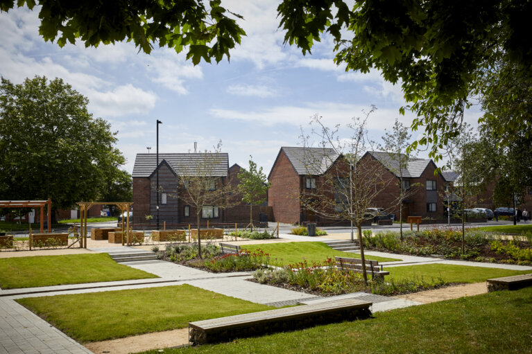 Residential houses with squares of green spaces in front of them that soak up excess water during heavy rains to help prevent floods.