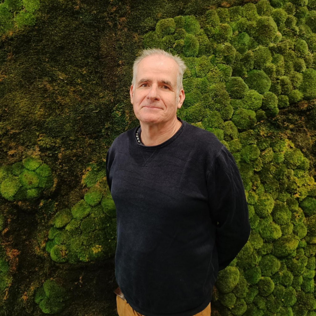 Man standing in front of moss wall
