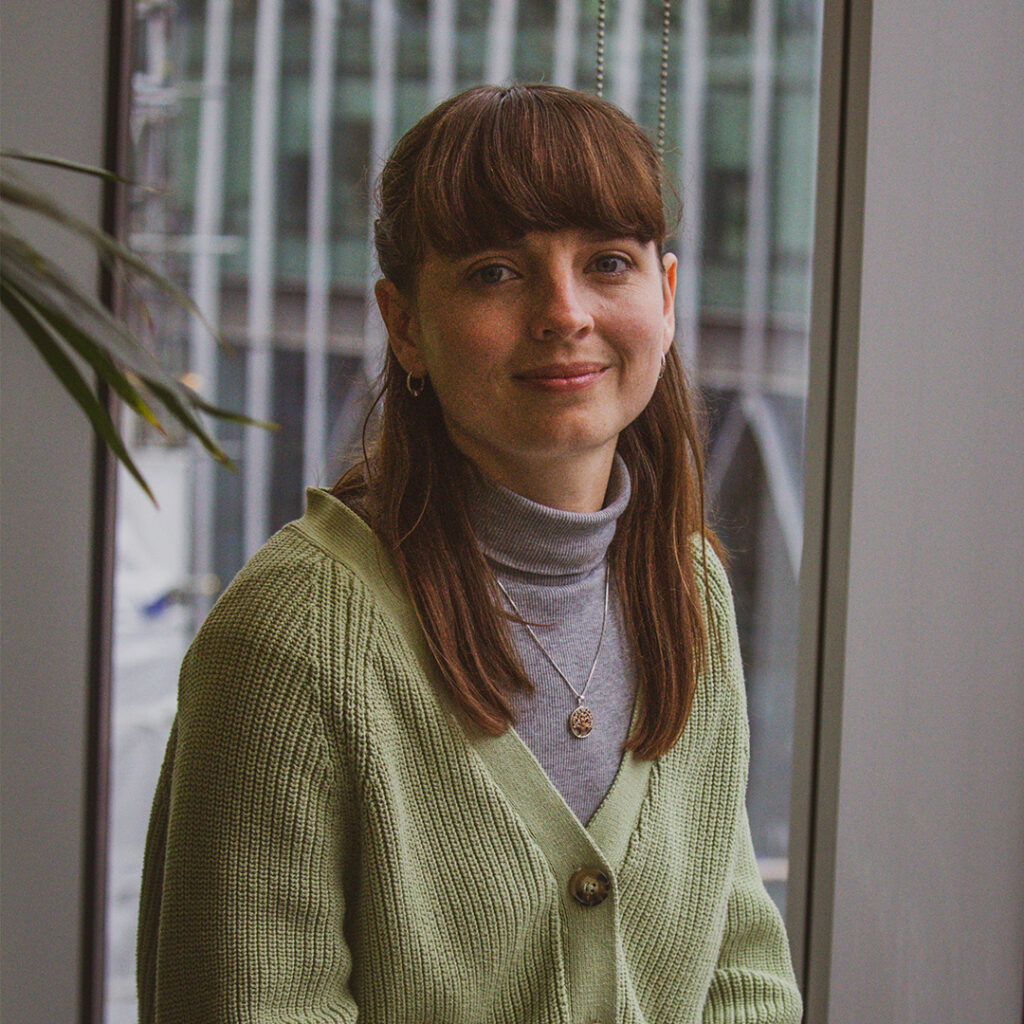 Woman in green jumper smiling at camera