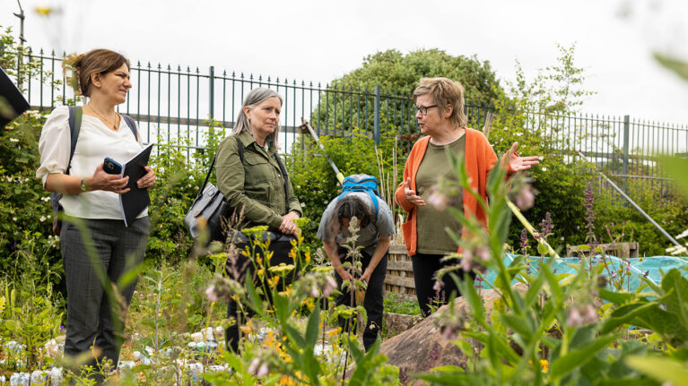 A group of people outside in nature talking to each other