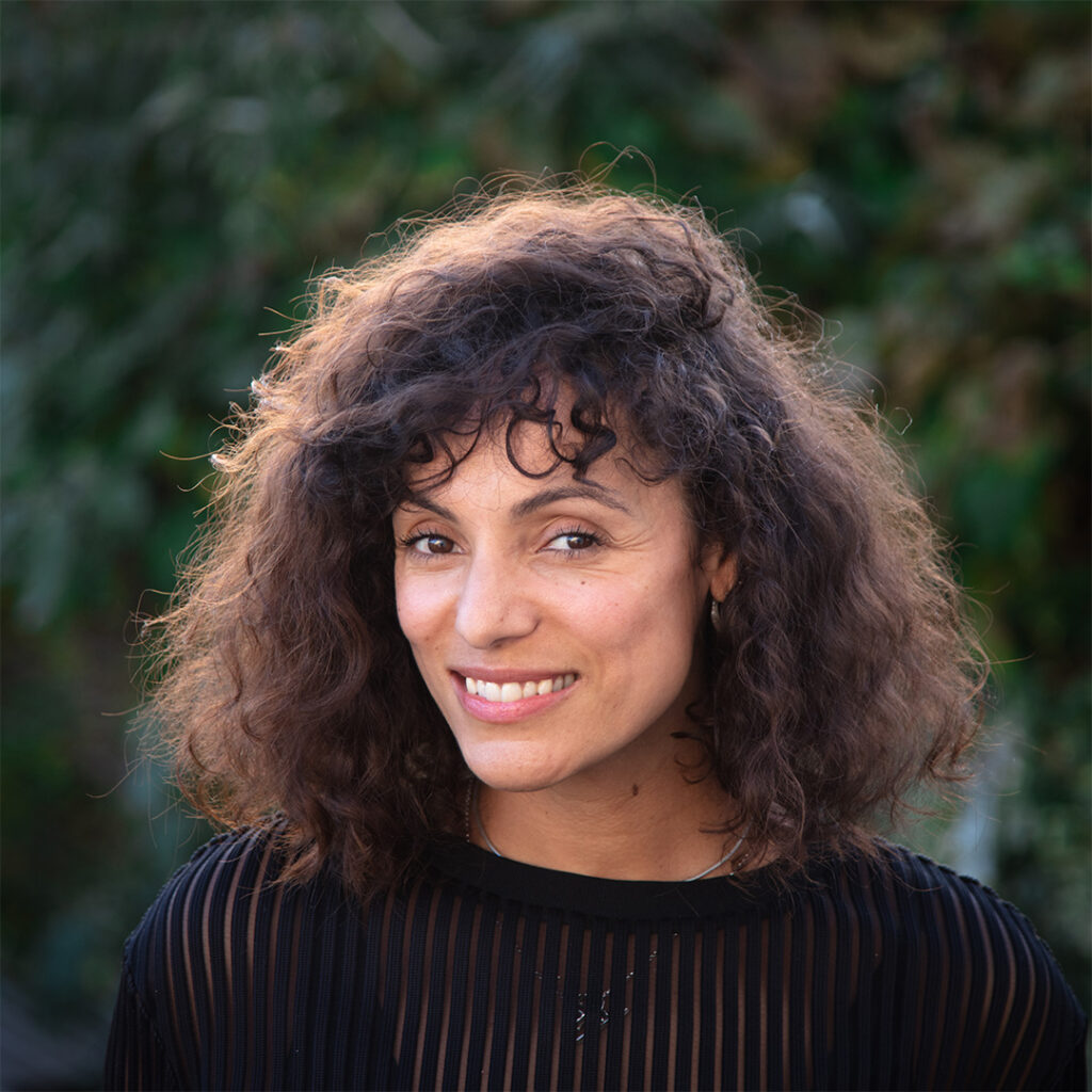 Woman with curly hair smiling at the camera