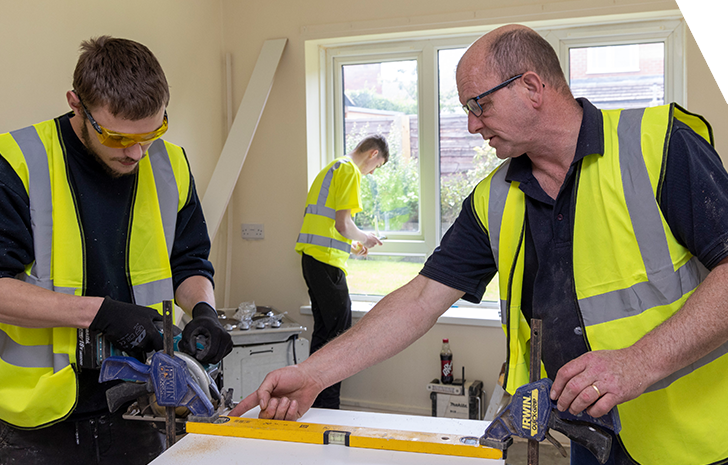 Two young apprentices are learning how to retrofit a house to become more energy efficient.