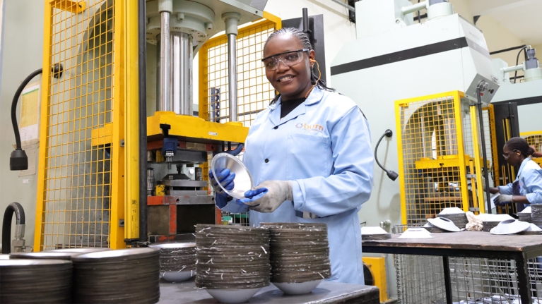 A Burn factory worker in the factory smiling at the camera