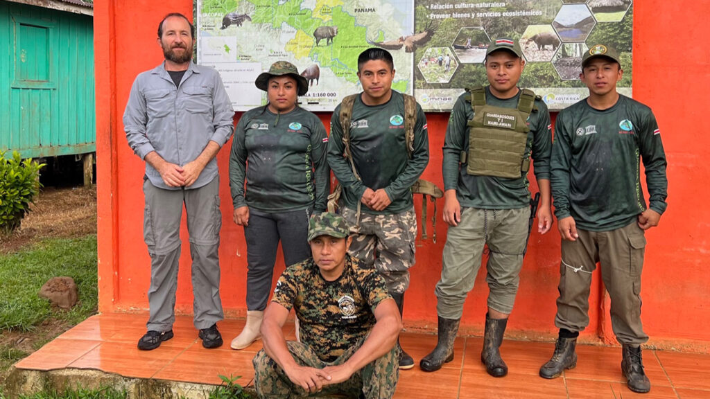 6 male standing in front of a map