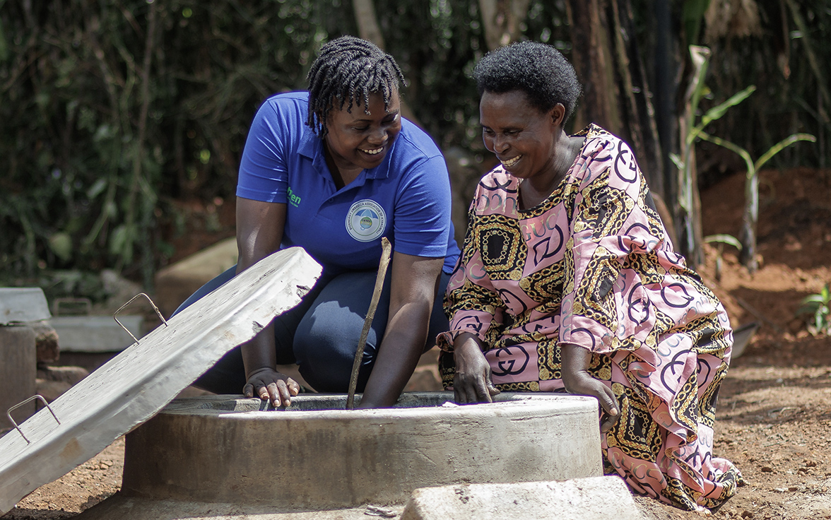 Two women from Bio-Energy Umbrella Association of Kyangwali are filling up their household biodigester that produces nutrient-rich bio-slurry that boosts agricultural production.