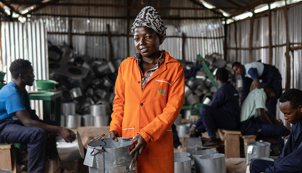 A woman in stood in factory based in a refugee settlement in Africa that is making clean energy cook stoves.
